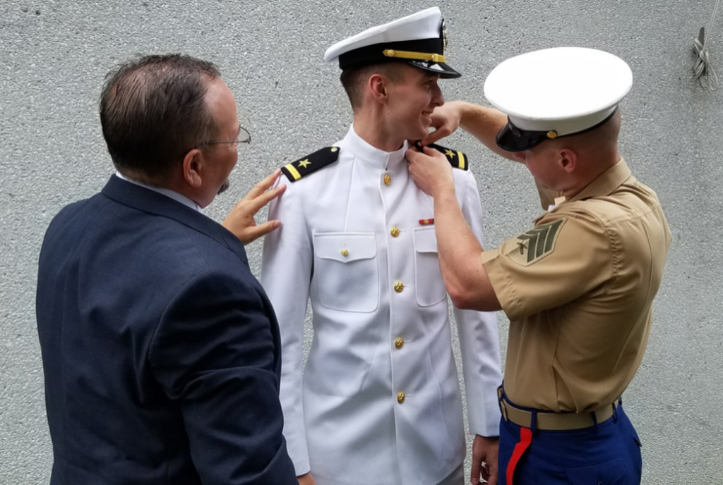 Andy and Marine Son Joel pinning Andrew's Shoulderboards on at USNA Graduation